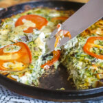 Knife lifting sfougato in cast iron skillet.