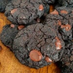 Double Chocolate Cookies on wooden chopping board with glass of milk