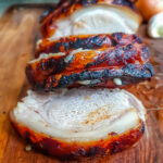 Paleo Pork Loin sliced on a wooden chopping board.