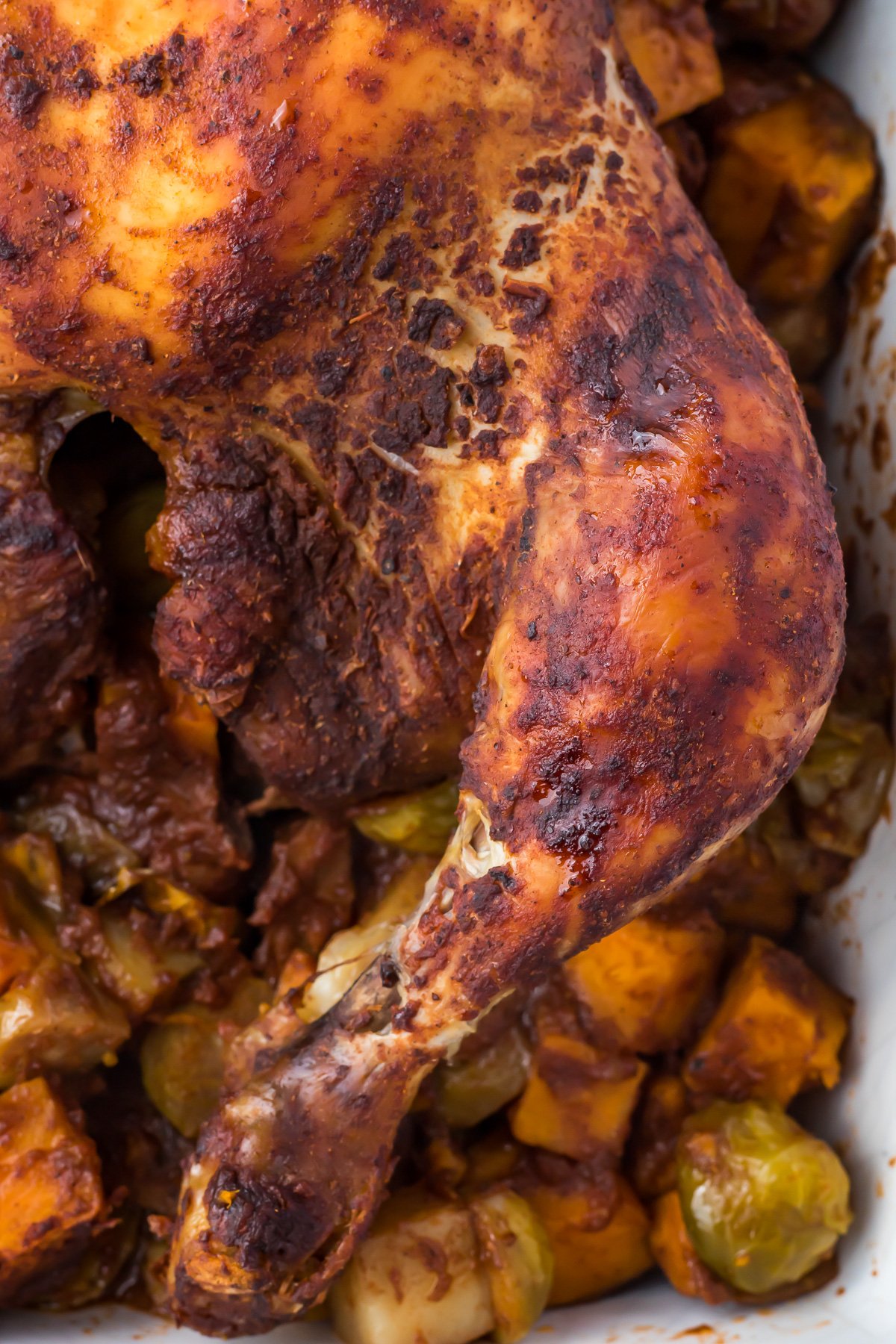 Close up of a chicken leg on a roasted chicken.