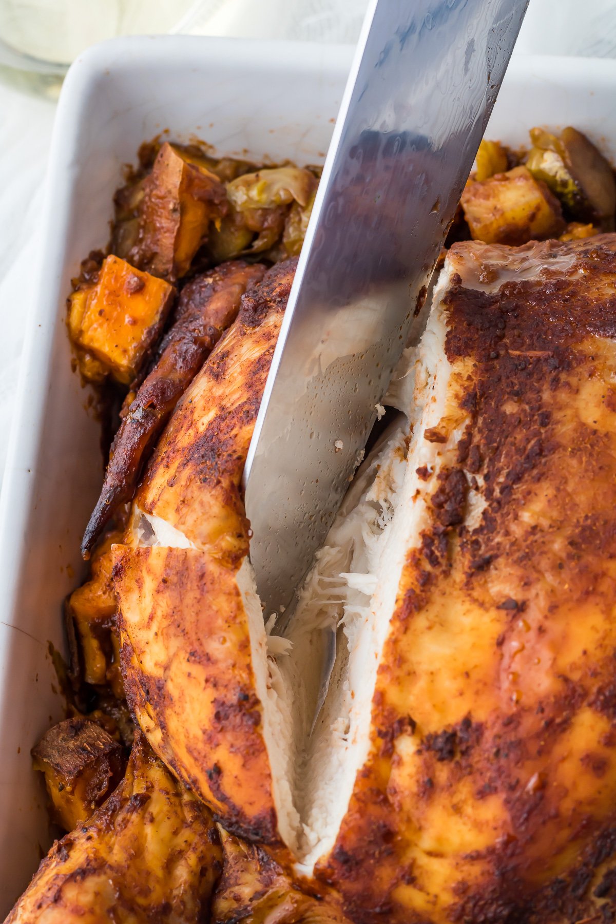 Knife slicing open chicken breast.