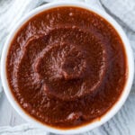 Overhead shot of sugar free bbq sauce in a white bowl surrounded by a white cloth.