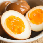 Paleo ramen eggs in a white bowl.