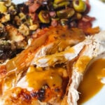 Gluten-free turkey gravy over turkey on a white plate with vegetables.