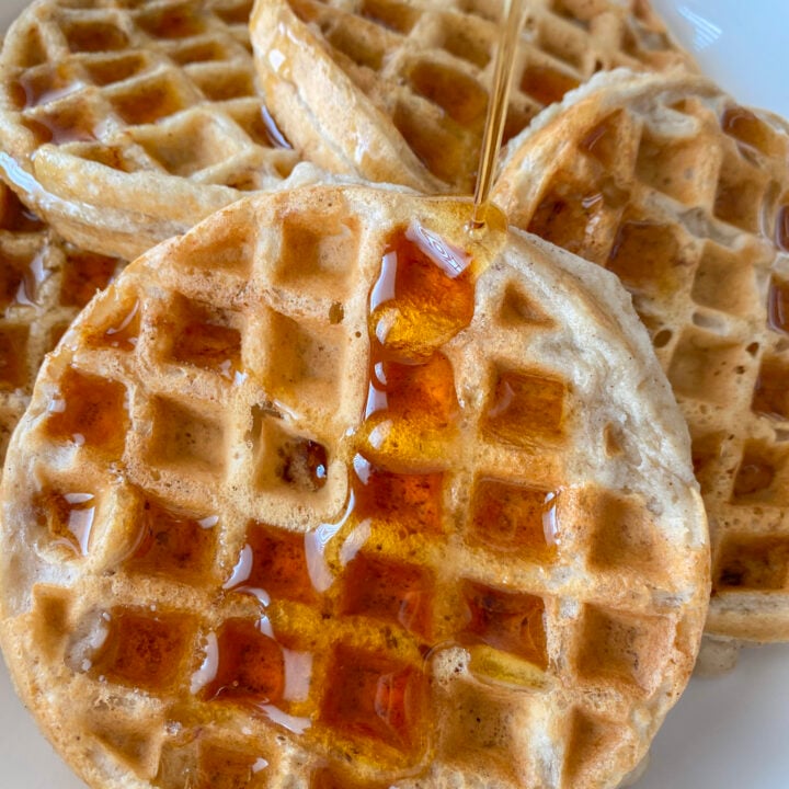 Waffles with syrup being poured over.