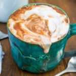 A green mug of oat milk hot chocolate.