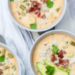 Overhead photo of three bowls of keto white chicken chili with avocado and bacon.