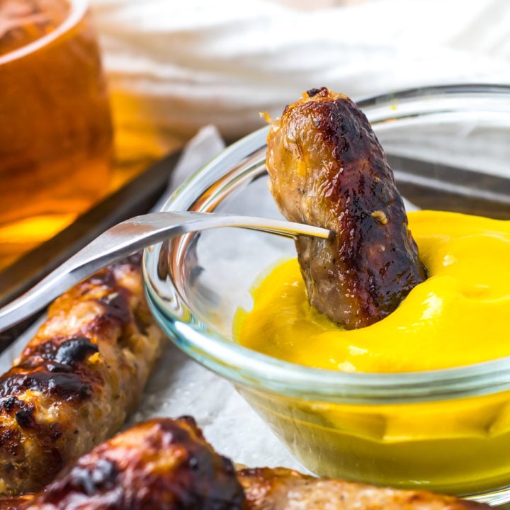 Air Fryer Sausage link being dipped in mustard.
