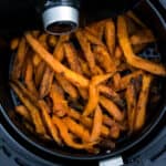 Overhead shot of sweet potato fries in an air fryer.