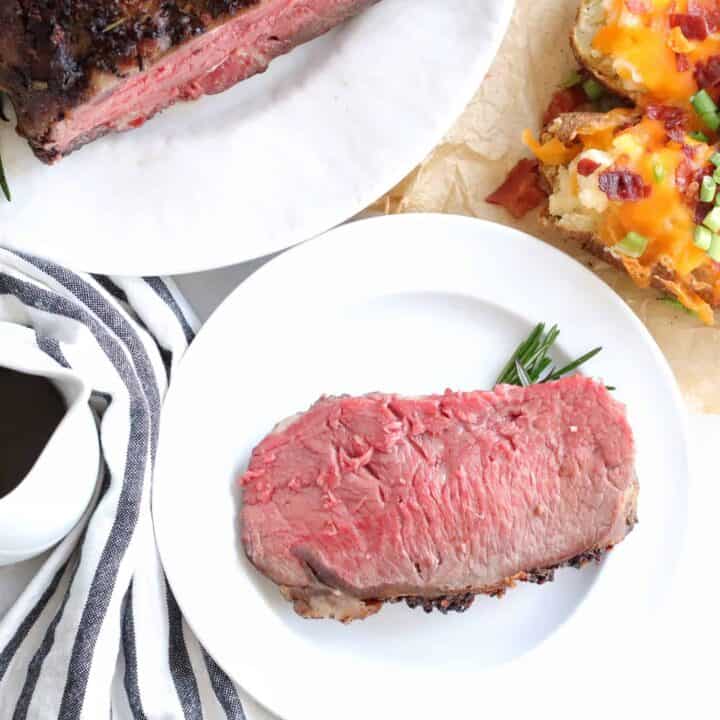 A plate of meat and a side of food.