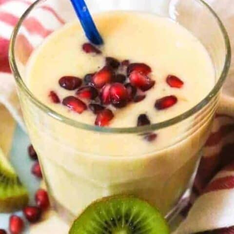 A glass of smoothie with fruit.