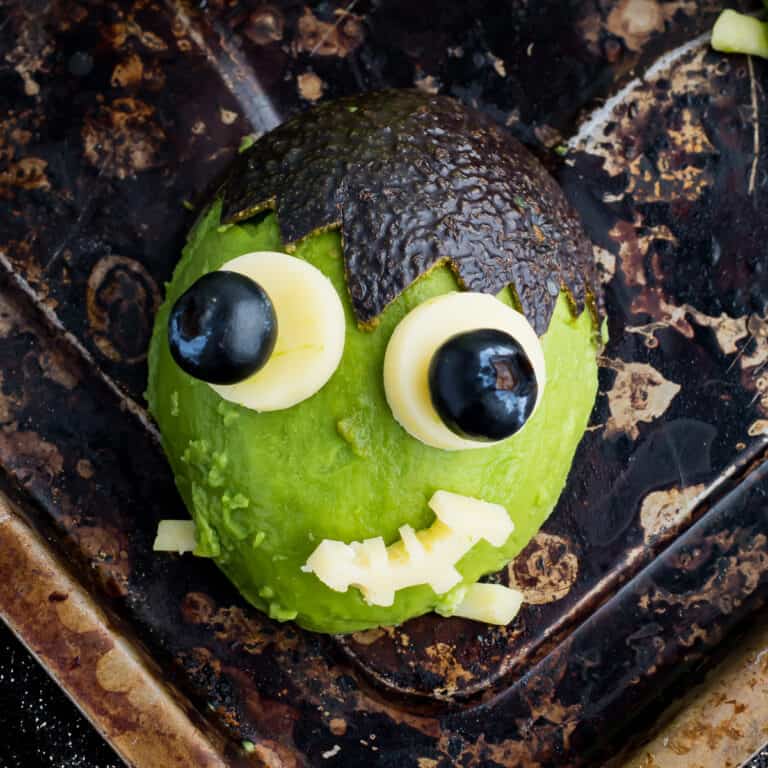 Overhead shot of Frankenstein avocado on a baking tray.