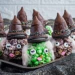 Witch Halloween popcorn balls on a tray.