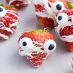 Halloween Strawberries with candy eyes on a grey plate.