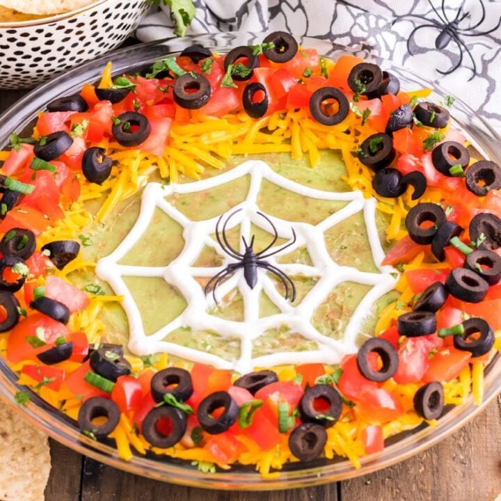 Two green martinis with spiders on them.