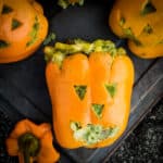 A stuffed bell pepper with jack-o-lantern faces, perfect for Halloween.