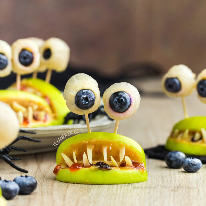 A plate of apple monsters with blueberries and blue eyes.
