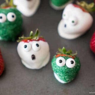 A plate of strawberries with eyes on them.