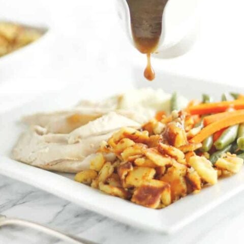 Keto Christmas Side Dishes include a plate of turkey and vegetables with gravy poured over.