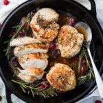 Overhead shot of Thanksgiving Chicken Breast recipe in a cast iron skillet with a spoon.
