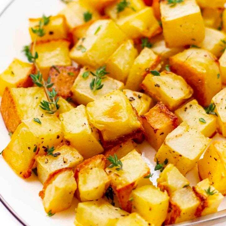 Roasted potatoes with thyme and rutabaga on a plate.