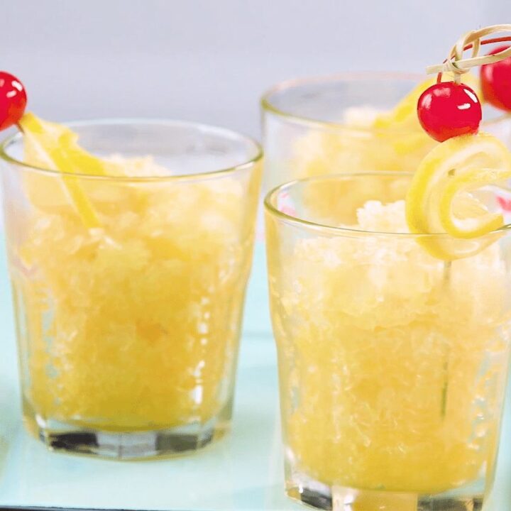 Three glasses of lemonade with cherries on top.
