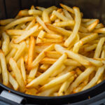 French fries in an air fryer basket.