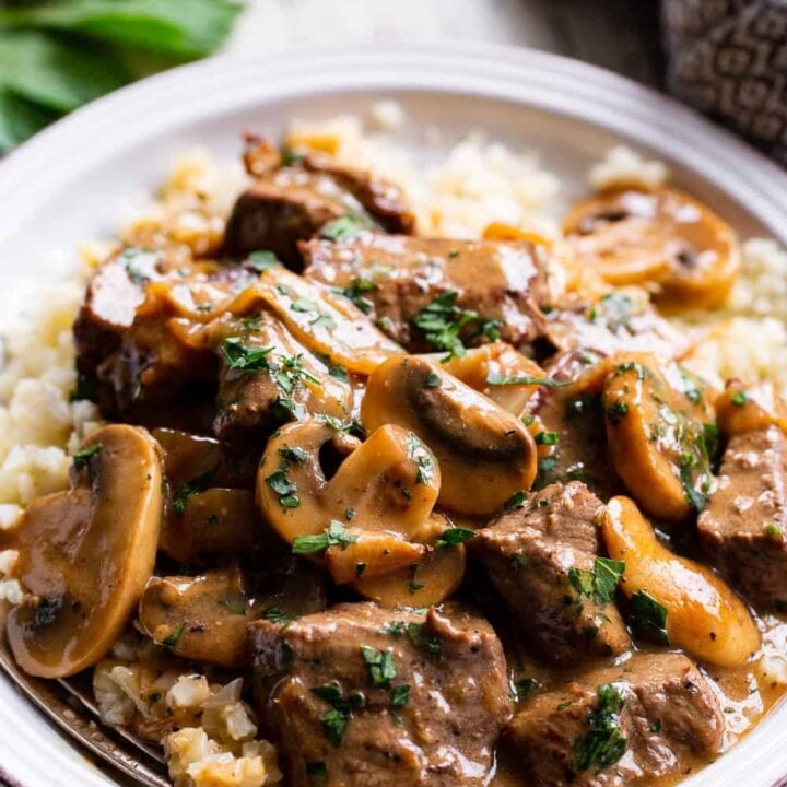 A plate of beef and mushroom gravy with rice.