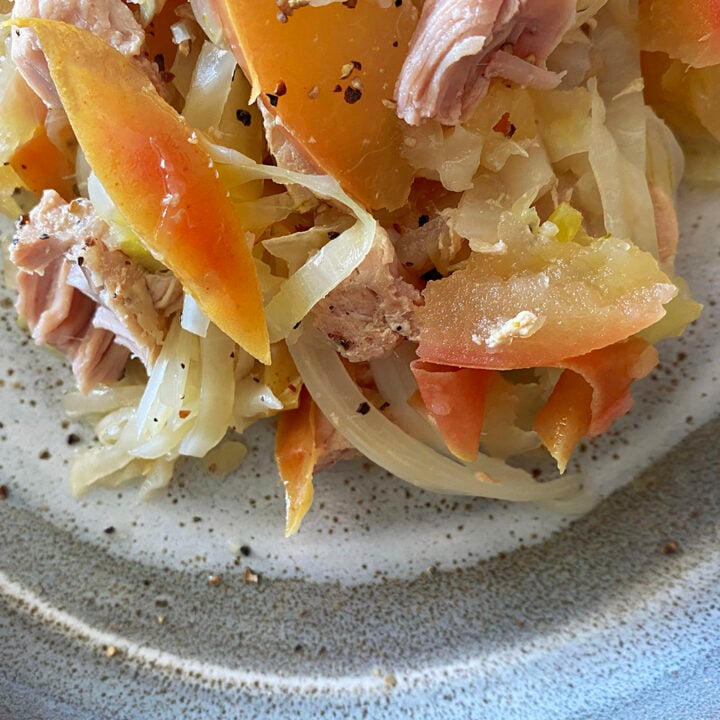 A plate of food on a table, featuring sauerkraut.
