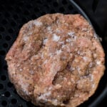 Frozen hamburger in an air fryer.