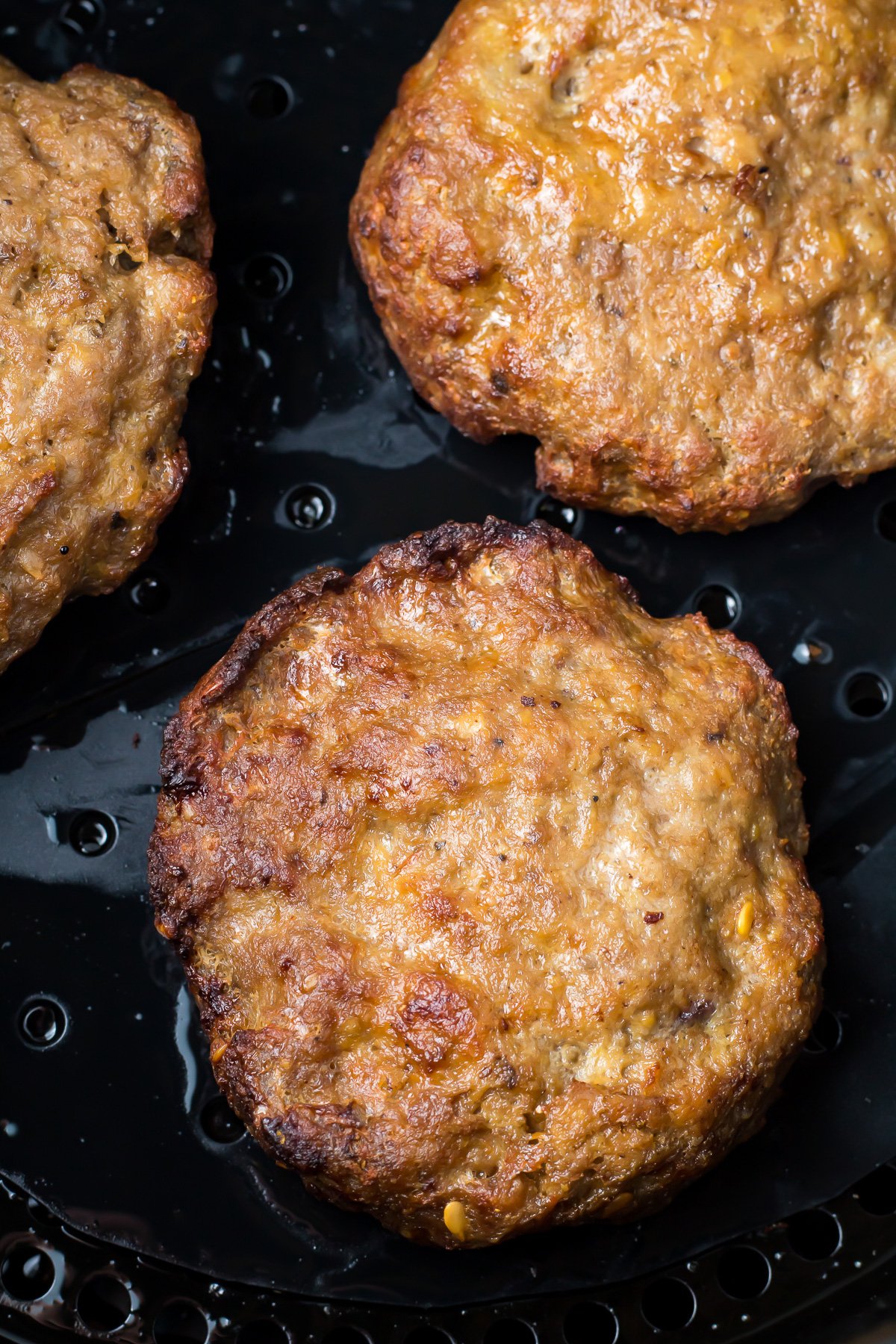 Overhead shot of air fryer hamburgers.