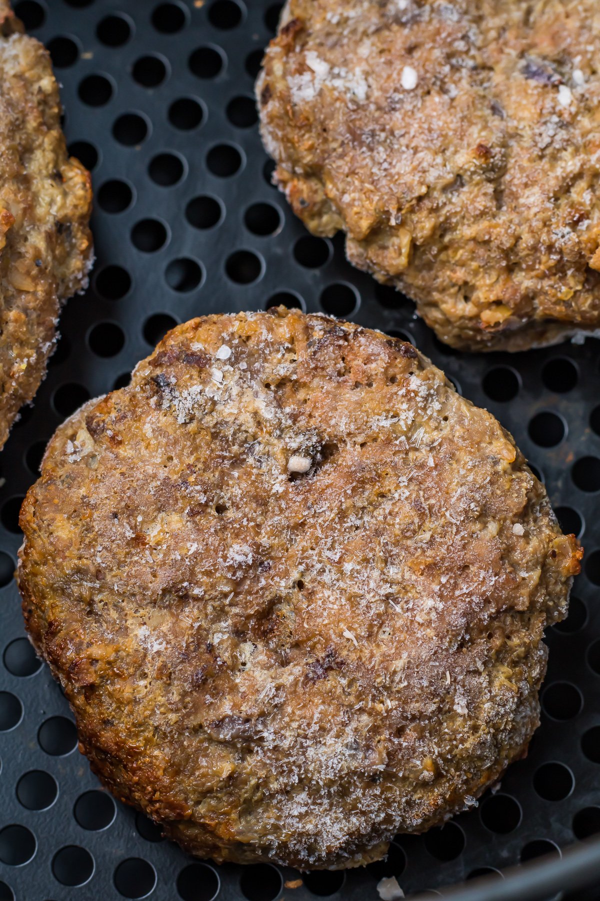 Frozen hamburgers in an air fryer.