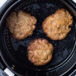 Overhead shot of reheated burgers in an air fryer.