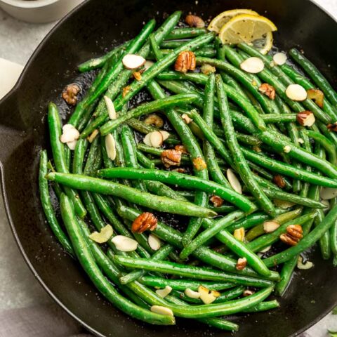 Low Carb Thanksgiving Green beans in a skillet with lemon and nuts.
