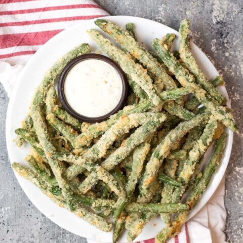 A low carb Thanksgiving side dish - roasted squash on a white plate, garnished with parsley.