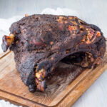 Smoked pork shoulder on a wooden chopping board.