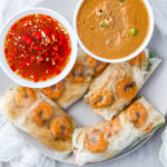 Overhead picture of shrimp summer rolls with nuoc cham and peanut dipping sauce.
