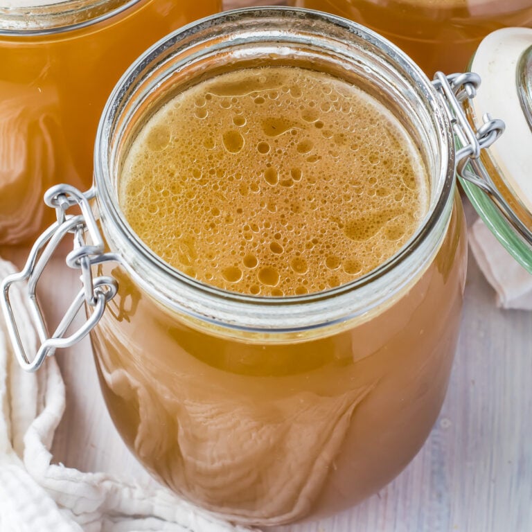 A jar of ham stock with the lid open.