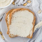 Overhead photo of vegan cream cheese on bread on a grey plate.