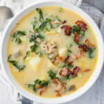 Overhead photo of a bowl of healthy zuppa toscana next to a pot of the soup.