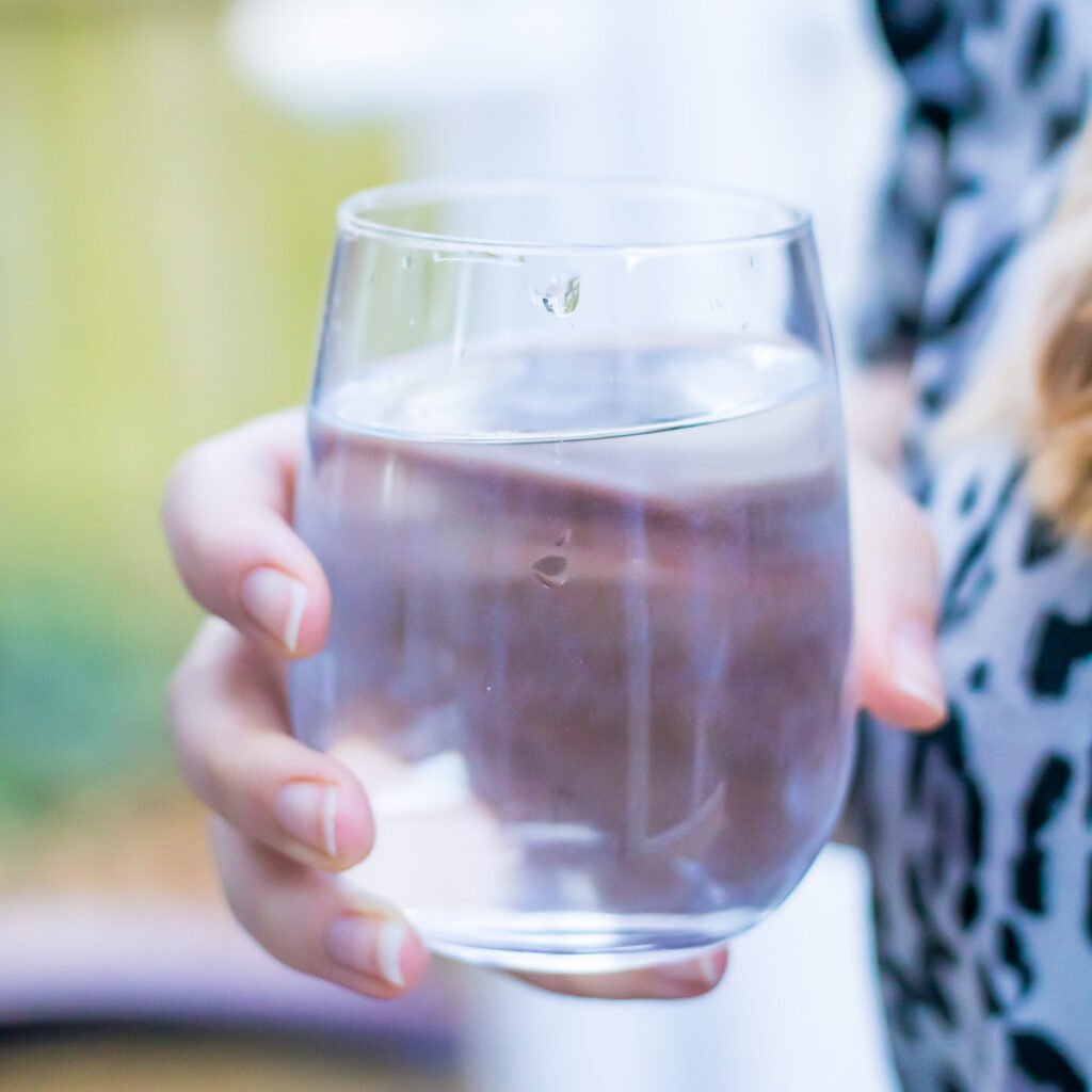 Hand holding a glass of water.