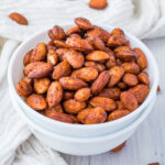Roasted cinnamon almonds in a white bowl.