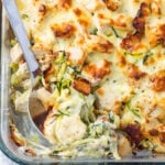 Overhead photo of keto chicken alfredo casserole with a serving spoon.