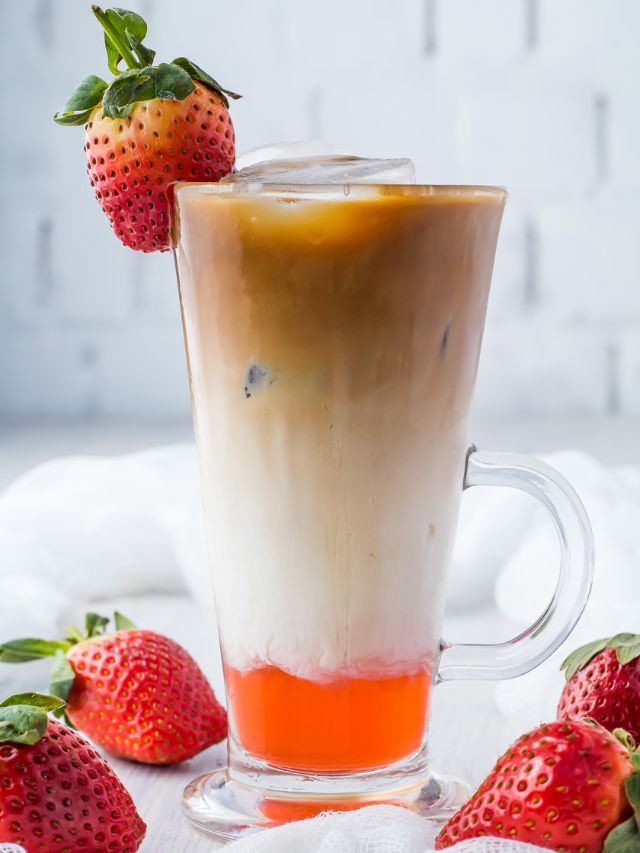 A strawberry iced coffee with strawberries.