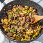 Keto Beef and broccoli stir fry in a wok with a wooden spoon.
