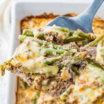 A keto green bean hamburger casserole, topped with melted cheese.