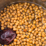 Cooked instant pot chickpeas and an onion in broth.