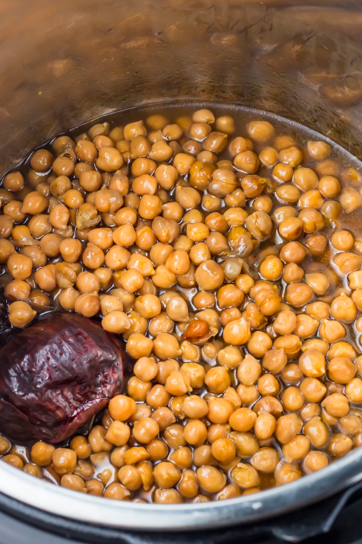 Cooked instant pot chickpeas and an onion in broth.