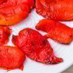 Roasted red peppers arranged on a white plate.