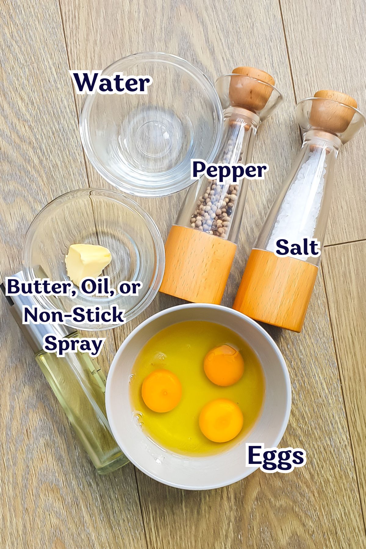 Clear glass bowls containing water, butter, and cracked eggs, next to salt and pepper grinders, arranged on a wooden surface.